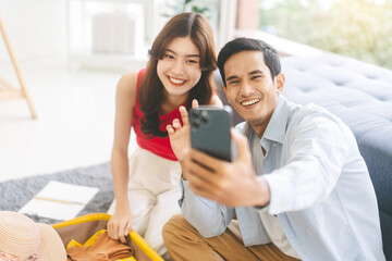 Wall Mural - Young adult southeast asian couple selfie together for upload internet social media before travel