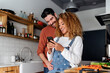 Couple looking at a smartphone in kitchen.