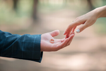 A young man holds a golden ring while proposing to his lover.
A young man confesses his love to a girl