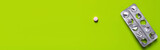 Fototapeta Kawa jest smaczna - top view of used blister pack near round shape pill on green background, banner.