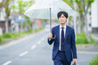 © 茂輝 田代 - 雨で傘をさすスーツの男性