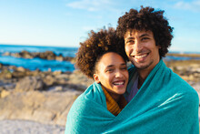 Portrait Of Loving Cheerful Afro African American Young Couple Wrapped In Blanket At Beach