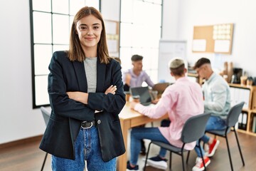 Sticker - Young hispanic businesswoman smiling happy standing with arms crossed gesture at the office during business meeting.