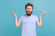 © khosrork - What do you want? Portrait of annoyed frustrated bearded man standing with raised hands and indignant face asking why, annoyed by problem. Indoor studio shot isolated on blue background.