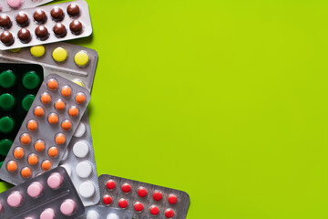 Wall Mural - top view of blister packs with different pills isolated on yellow-green background.