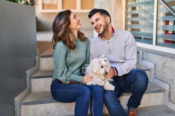 Poster - Man and woman holding dog sitting together at street