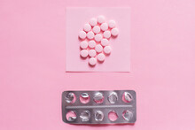 Top View Of Round Shape Pills On Paper Note Near Empty Blister Pack On Pink.