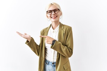 Sticker - Beautiful caucasian business woman standing over isolated background amazed and smiling to the camera while presenting with hand and pointing with finger.