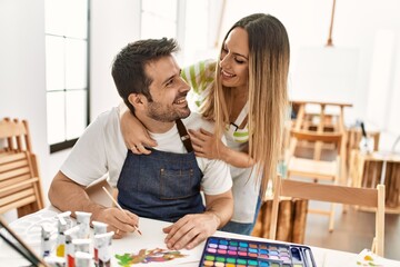 Two students smiling happy painting sitting on the table at art school.