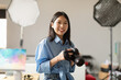 Portrait Of Smiling Asian Woman Holding Photo Camera Posing