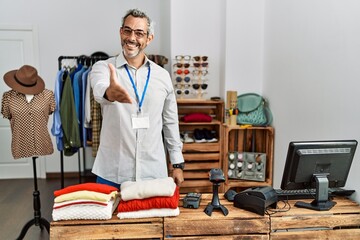 Sticker - Middle age hispanic man working as manager at retail boutique smiling friendly offering handshake as greeting and welcoming. successful business.