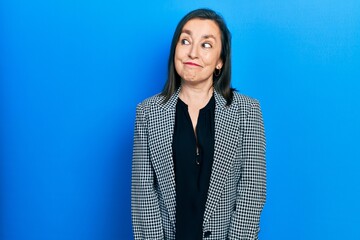 Wall Mural - Middle age hispanic woman wearing business clothes smiling looking to the side and staring away thinking.