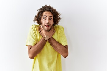 Poster - Young hispanic man standing over isolated background shouting and suffocate because painful strangle. health problem. asphyxiate and suicide concept.