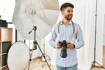 Poster - Young arab photographer man smiling happy using reflex camera at photo studio.