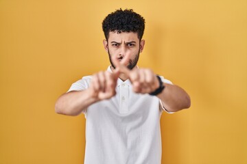 Poster - Arab man standing over yellow background rejection expression crossing fingers doing negative sign