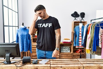 Wall Mural - Young hispanic man working at retail boutique tired rubbing nose and eyes feeling fatigue and headache. stress and frustration concept.