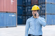 © charnsitr - Caucasian Supervisor Talking on Mobile Phone at Logistic Cargo Containers Site