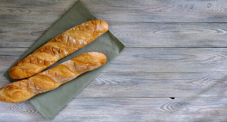 Fresh baguette with crispy crust on a wooden board close -up