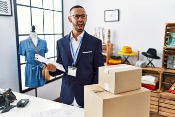 Poster - African american man working as manager at retail boutique angry and mad screaming frustrated and furious, shouting with anger. rage and aggressive concept.