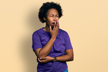 Canvas Print - African american woman with afro hair wearing casual purple t shirt bored yawning tired covering mouth with hand. restless and sleepiness.