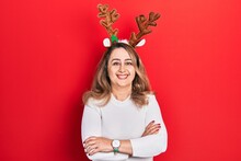 Middle Age Caucasian Woman Wearing Cute Christmas Reindeer Horns Happy Face Smiling With Crossed Arms Looking At The Camera. Positive Person.
