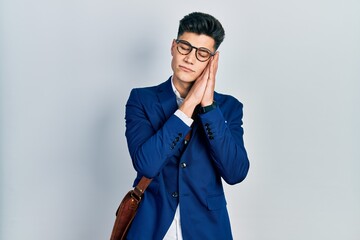 Canvas Print - Young hispanic man wearing business clothes sleeping tired dreaming and posing with hands together while smiling with closed eyes.