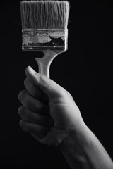 Paint brush in hand on a black and white image.