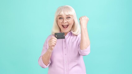 Poster - Aged lady enjoy bank offer deposit card fist up isolated cyan color background