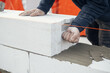 Masonry. Worker laying autoclaved aerated concrete blocks. Builder installing white blocks close up. Process of house building at construction site