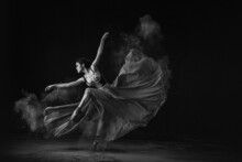 Grayscale Shot Of An Emotional Southeast Asian Ballet Dancer Performing A Move On A Black Background