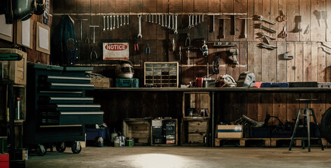 Workshop scene. Old tools hanging on wall in workshop, Tool shelf against a table and wall, vintage garage style