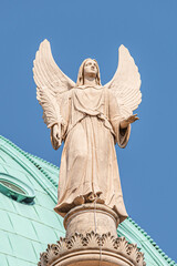 Wall Mural - Statue of winged angel at Evangelical church Saint Nikolai at sunset and blue sky, Potsdam, Germany