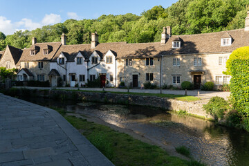 Poster - Brown stone cottages surrounded by green vegetation. Castle Combe, England, UK.