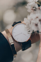 Wall Mural - Stylish elegant white watch on woman hand. Close-up photo.