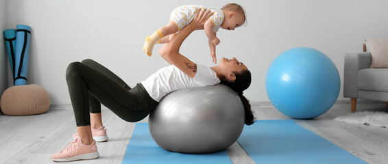 Canvas Print - Sporty young woman and her baby doing exercises with fitball at home