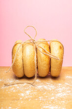 Freshly Bagels Tied Together With String With A Dusky Pink Background