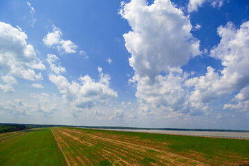  Sardis Dam, an Earthen Dam, and  reservoir lake on the Tallahatchie River at John W Kyle State Park in Panola County, Mississippi. With Blue, partly cloudy sky, and green grass.