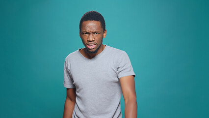 Violent furious man expressing anger and aggression in studio, having argument in front of camera. Unhappy aggressive person clenching fists and feeling frustrated, conflict disagreement.