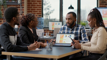 Sticker - African american team of people collaborating on business strategy development, planning financial charts presentation for company growth. Job colleagues doing teamwork and collaboration with laptop.