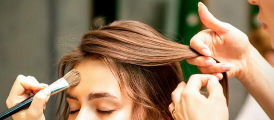 Wall Mural - Makeup artist and hairdresser prepare the bride making hairstyle and makeup in a beauty salon