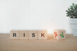 risk word with flipped , turned down to up percent icon, on wooden cube block for business strategy , business risk management concept