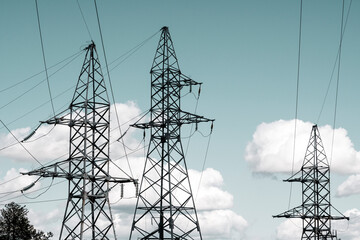 High voltage transmission towers on sky background