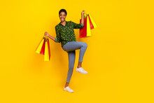 Photo Of Excited Funky Androgynous Person Dressed Smart Casual Walking Holding Shoppers Isolated Yellow Color Background