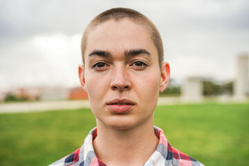 Young bald girl looking at camera outdoor - Focus on face