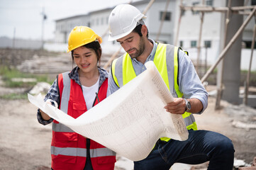 Mechanical Engineer team Working with paper work on construction home building site	