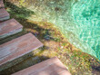 Closeup of wooden footpath and clear water pond or pool for travel, vacation concept