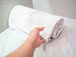 Closeup of women 's hand and white low quality towel on marble counter in hotel bathroom for cleaning service concept