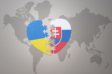 puzzle heart with the national flag of ukraine and slovakia on a world map background. Concept.