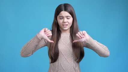 Poster - Teen lady make thumb down symbol not like ads isolated blue color background