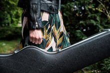 Close Up Of Woman Arm Holding A Guitar Case In A Park.